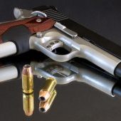 bi tones handgun that's on a mirror with bullets